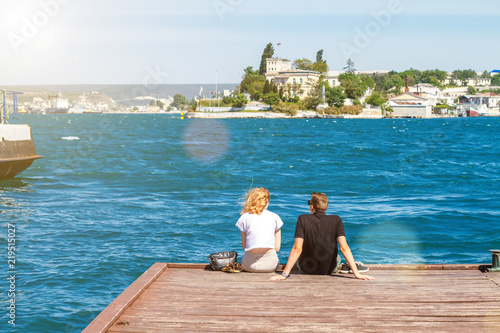 couple sitting on the pier on a Sunny day