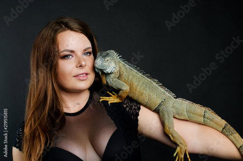 beautiful girl and big green iguana in the studio
