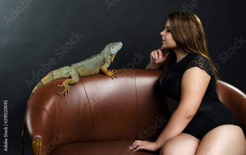 beautiful girl and big green iguana in the studio
