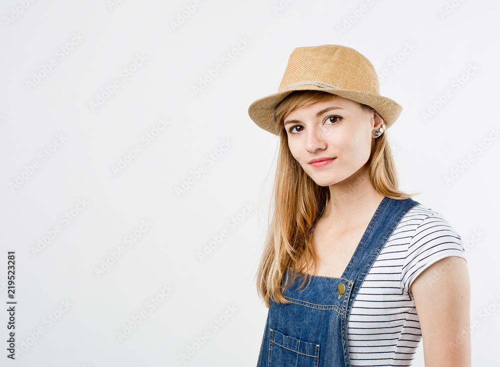 Beautiful young woman wearing a denim jeans, t-shirt and summer hat summer hipster hat. Traveling style girl on white background with space for your text Beautiful young woman wearing a denim jeans, t-shirt and summer hat summer hipster hat. Traveling style girl on white background with space for your text
