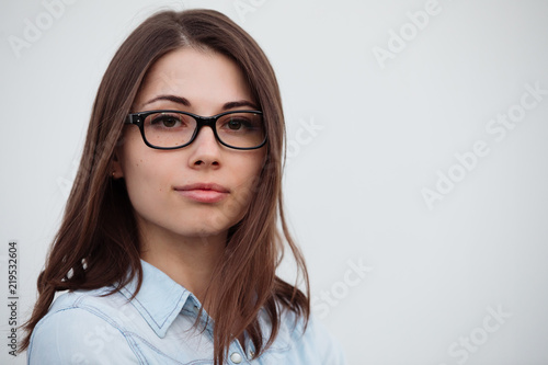 Confident woman in glasses on white background