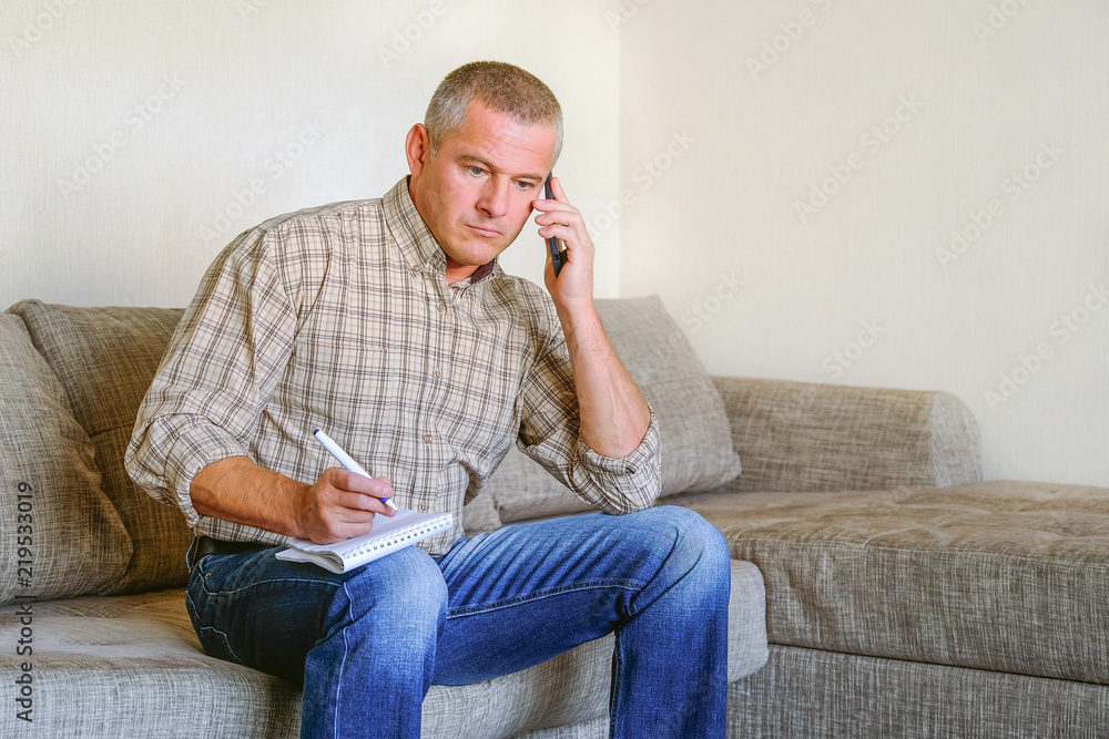 Man sitting on the phone, emotions on his face. Man sitting on the phone, emotions on his face.