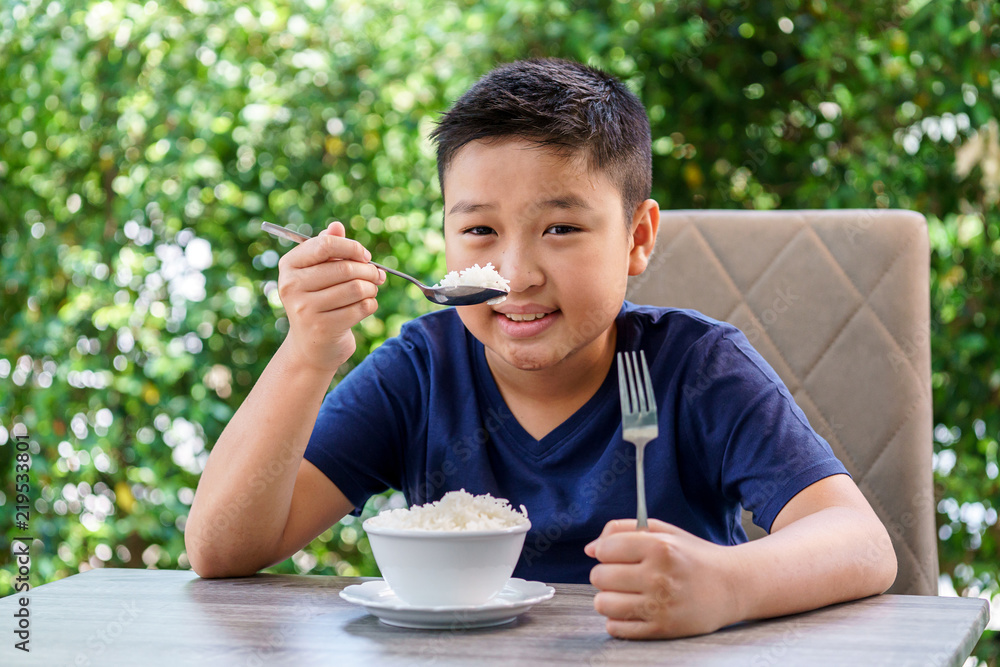 Boy eat white rice in a garden. Boy eat white rice in a garden.