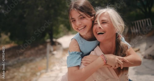 Grandmother and granddaughter having fun in summer with piggyback ride