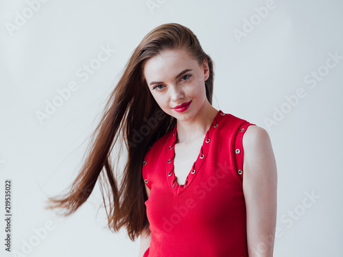 Beautiful woman brunette with long hair in red dress and red lipstick natural portrait