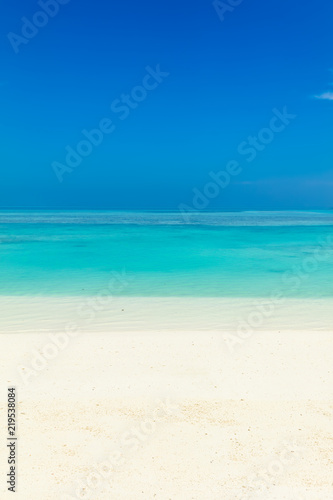 Blue sea water surface, clear sky and sandy seashore