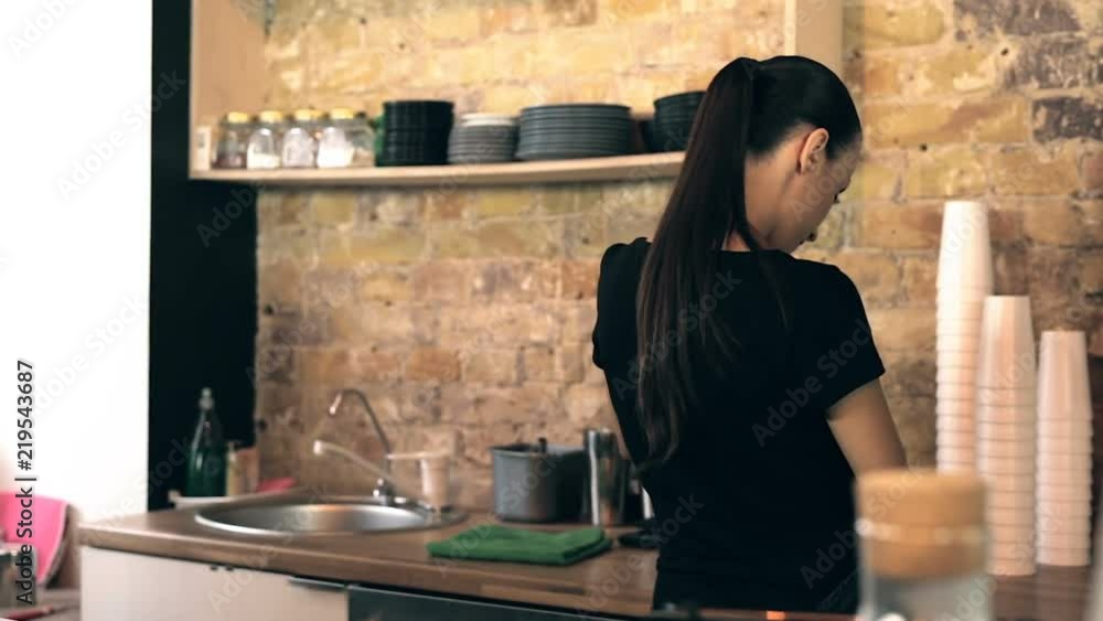 Waitress working in the coffee shop. View from back. Steadycam shot. Waitress working in the coffee shop. View from back. Steadycam shot.