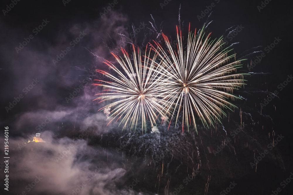 Couple of fireworks on the feast of the patron saint of the city whose church is visible in the background, Vittorio Veneto, Italy