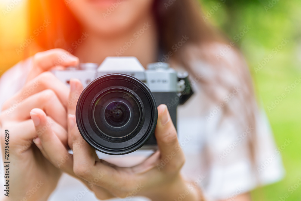 closeup front lens of mirrorless camera in woman teen photographer closeup front lens of mirrorless camera in woman teen photographer
