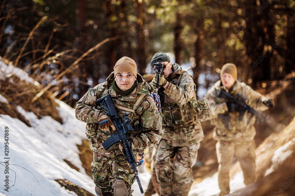 team of special forces weapons in cold forest. Winter warfare and military concept