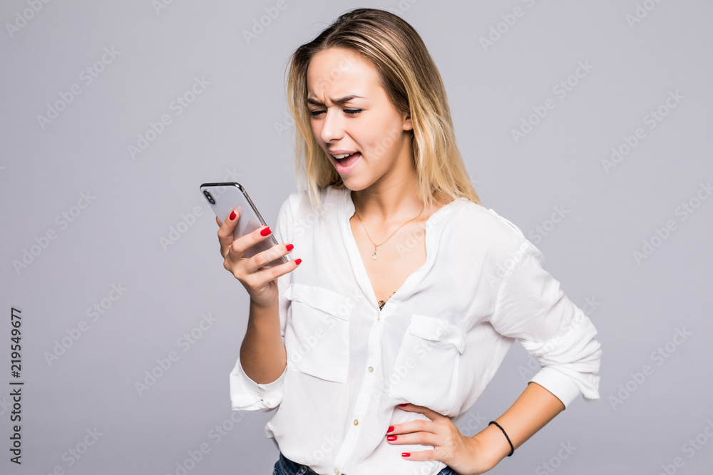 Woman in shirt screaming on phone in studio on gray background Woman in shirt screaming on phone in studio on gray background