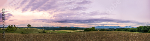 Rolling Landscape with Alps Mountains at Sunset.