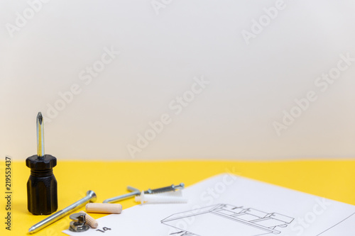 Group of equipment for furniture assembly on yellow board with space for text.