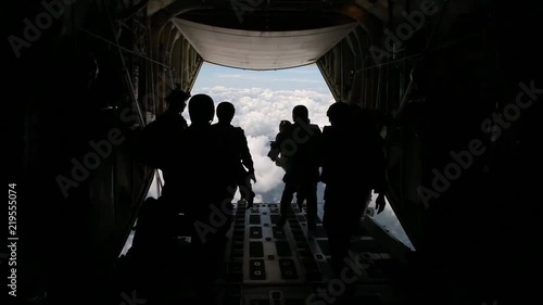 US Army paratroopers jumping from a military plane during special mission photo