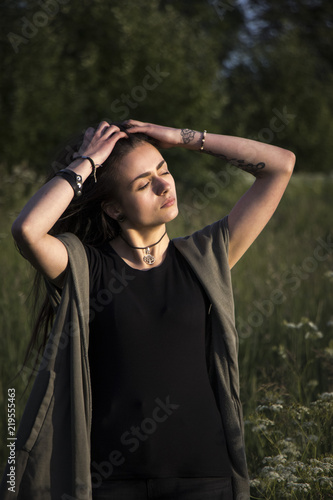 beautiful young girl in jacket lying down on grass