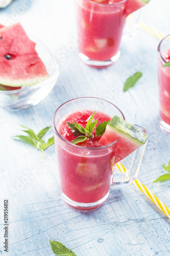 Summer drinks from watermelon with mint leaves over a blue table