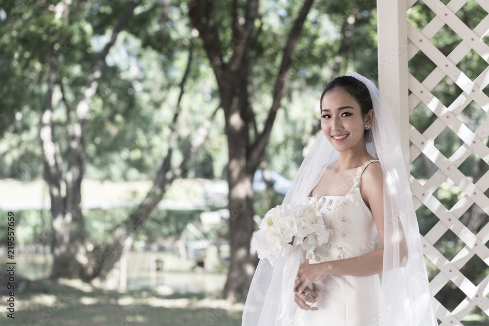 Beautiful Attractive Asian Bride Woman wearing wedding dress and holding bouquet smile and happiness in wedding day Beautiful Attractive Asian Bride Woman wearing wedding dress and holding bouquet smile and happiness in wedding day
