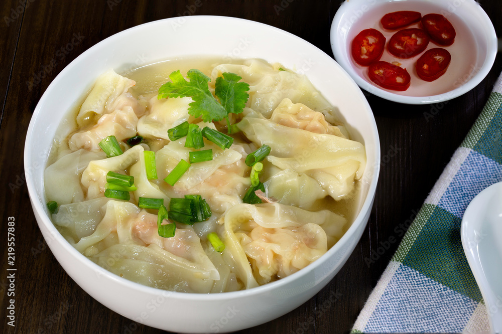 Shrimp wonton in hot soup in white bowl on wooden table Asia food Shrimp wonton in hot soup in white bowl on wooden table Asia food