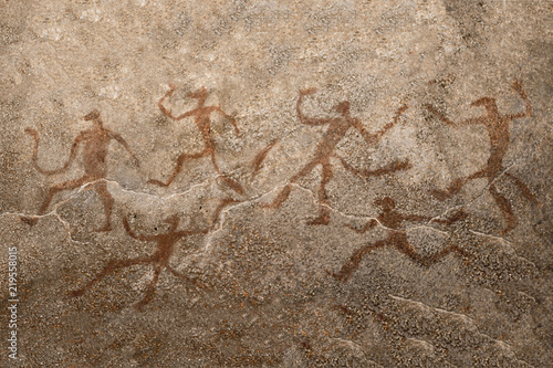 An image of ancient dancing people on the wall of the cave. history. stone age, archeology.