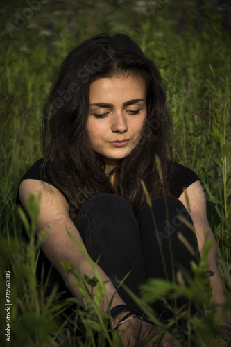 beautiful young girl in jacket lying down on grass © Nikita