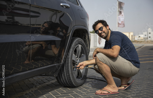 arab man inflating car tyre