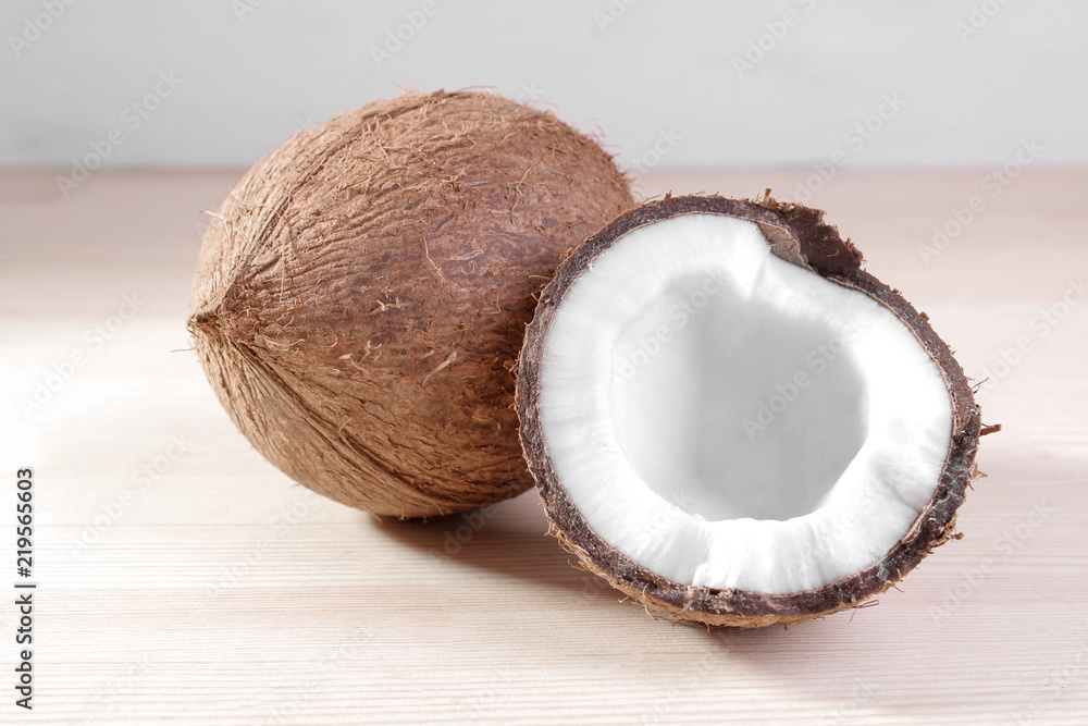 large fresh coconut and pieces of coconut on a natural wooden background large fresh coconut and pieces of coconut on a natural wooden background