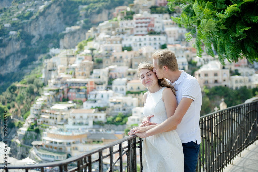 Young romantic couple in love, embracing in the background Positano, Italy