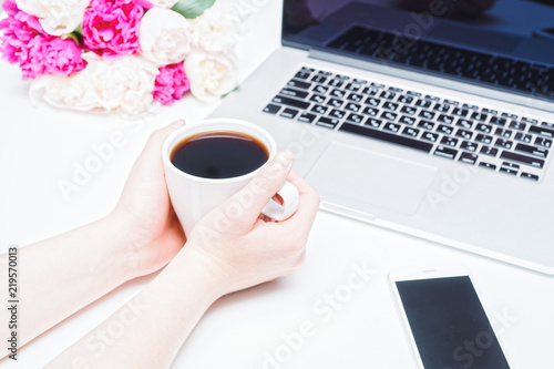 Workspace laptop mobile phone coffee female hands peony