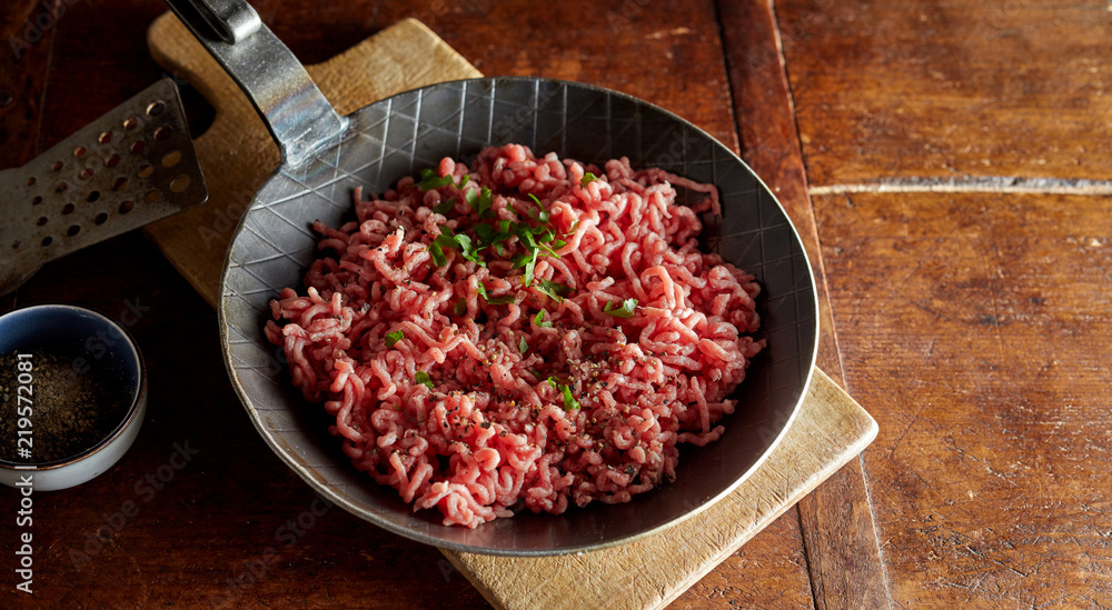 Raw minced meat with chives on pan Raw minced meat with chives on pan