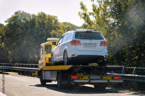 Tow truck with broken car on road