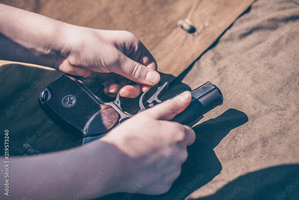 Fototapeta premium The boy performs disassembly, cleaning and assembly of the Makarov pistol