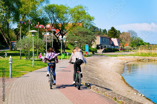 Fotografi Girls riding bicycle Nida resort at Curonian Spit Baltic Sea