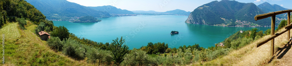 Panoramic view of mountain lake with island in the middle. Panorama from Monte Isola Island with Lake Iseo, Italy. Italian landscape. Island on lake. 