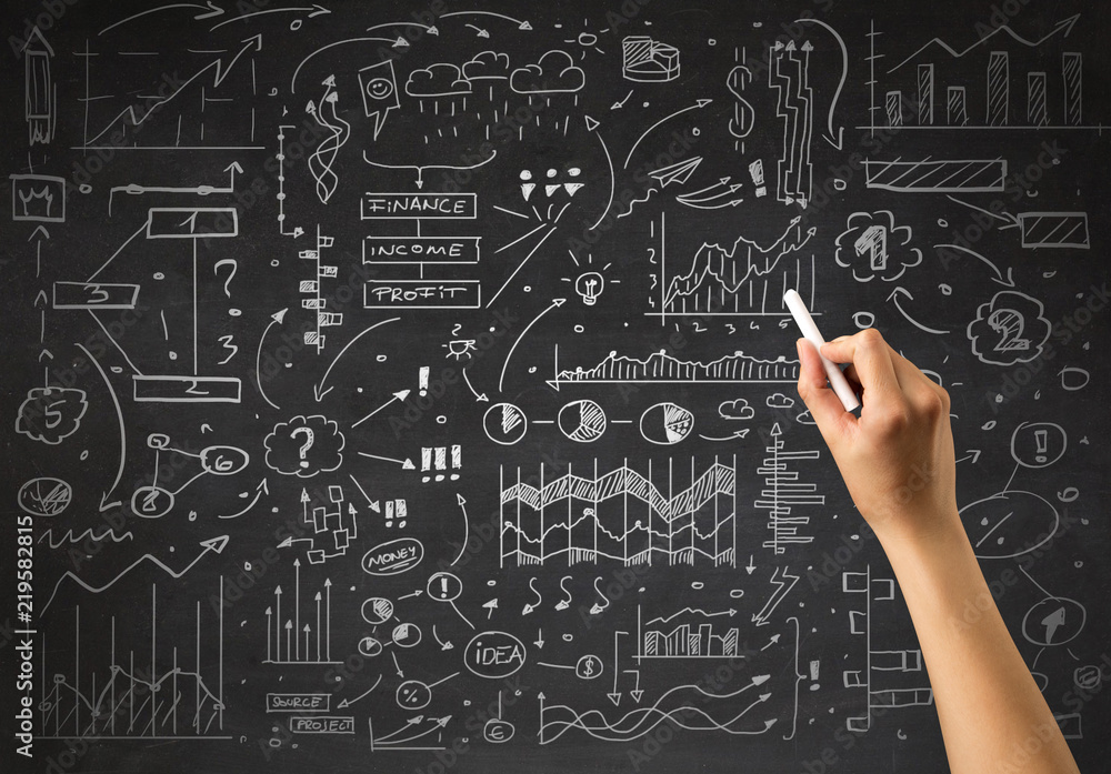 Female hand holding white chalk in front of a blackboard with a business plan drawn on it Female hand holding white chalk in front of a blackboard with a business plan drawn on it
