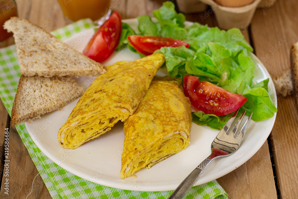 Rolled omelette with cheese served with vegetable salad