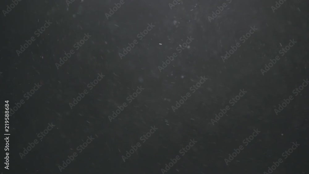 Slow motion explosion effect of backlit dust particles on a black background Slow motion explosion effect of backlit dust particles on a black background