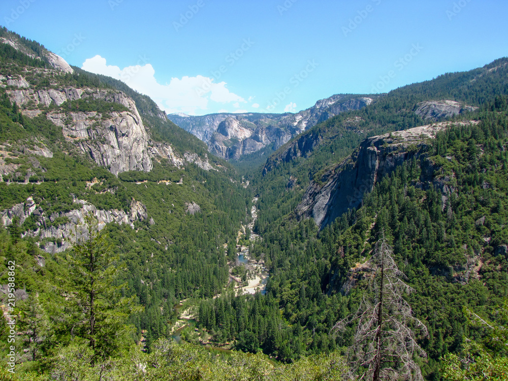 Panoramic view of mountains and a river running trough the valley at Yosemite National, California, USA