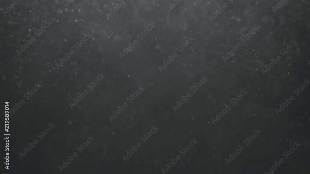 Slow motion explosion effect of backlit dust particles on a black background Slow motion explosion effect of backlit dust particles on a black background