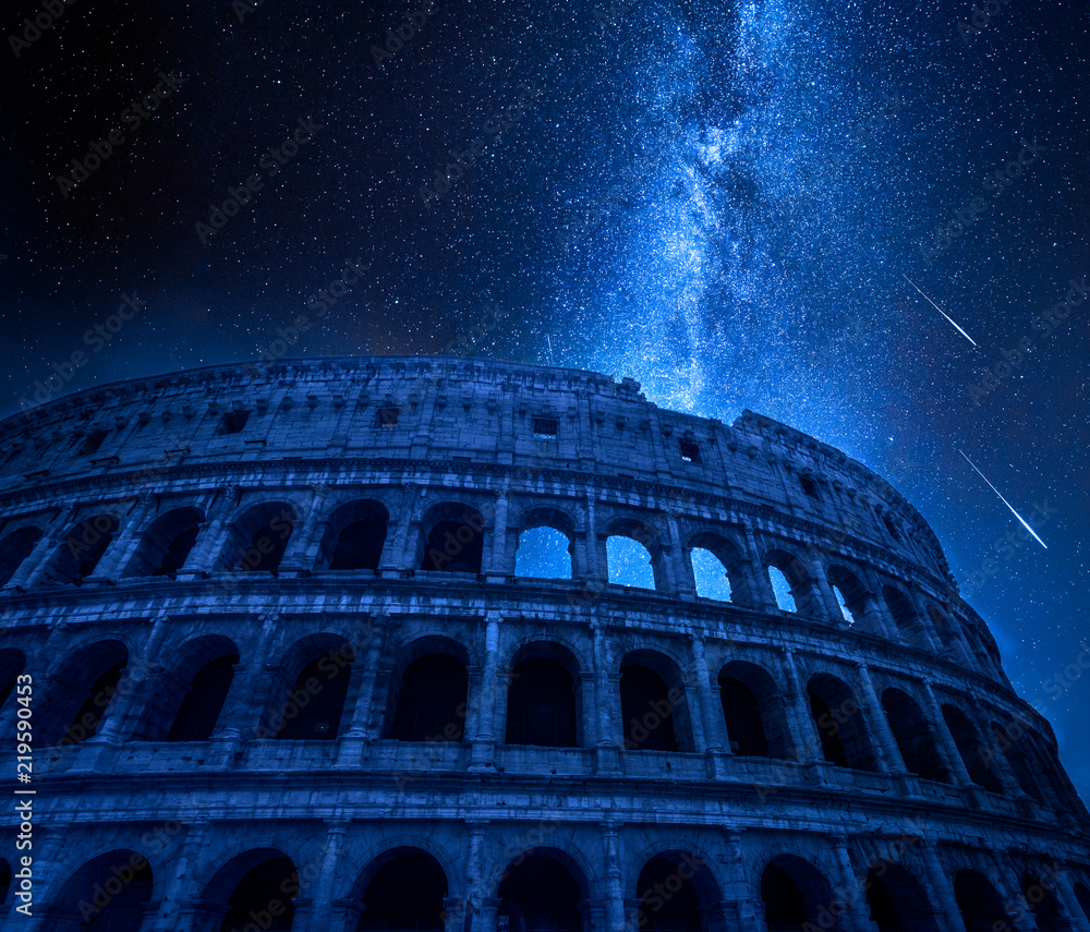 Fototapeta premium Oszałamiające Koloseum w Rzymie nocą z spadającymi gwiazdami, Włochy