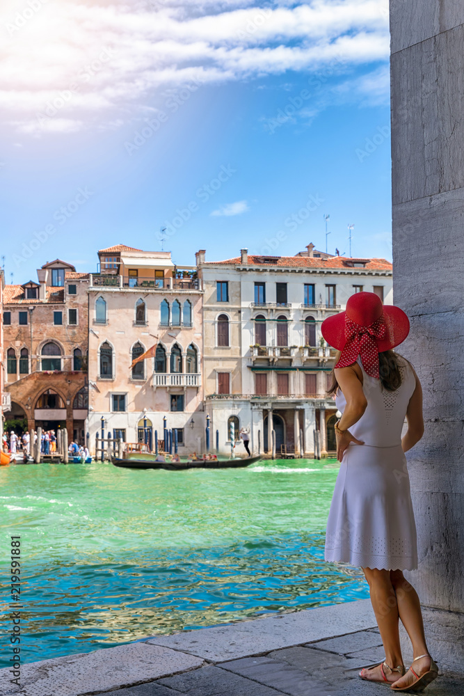 Fototapeta premium Atrakcyjny, noszony turysta w białej sukni wygląda na Canal Grande w Wenecji w słoneczny dzień, Włochy
