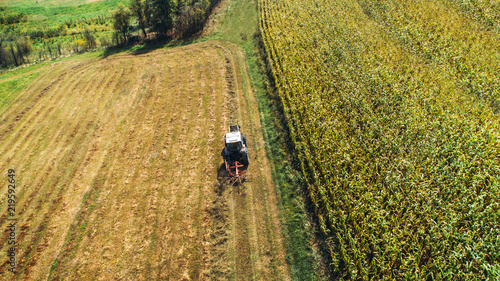 Tractor using rotary rakes machinery, harvesting details. Hay collecting and wheat production