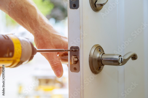 Valokuva Installation locked interior door knobs, close-up woodworker hands install lock