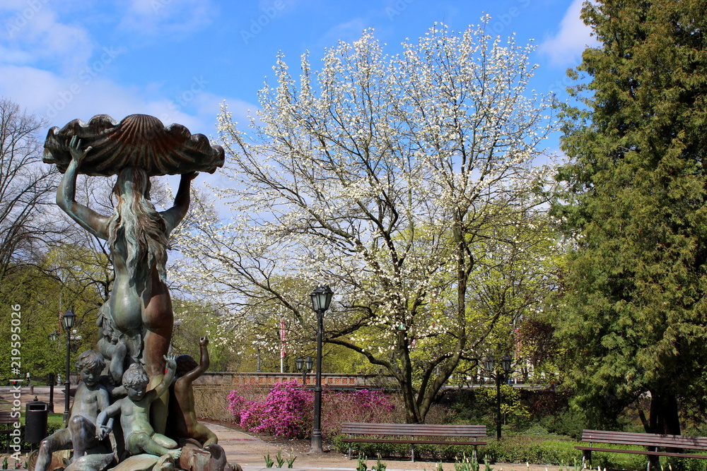 blooming park in riga with statue
