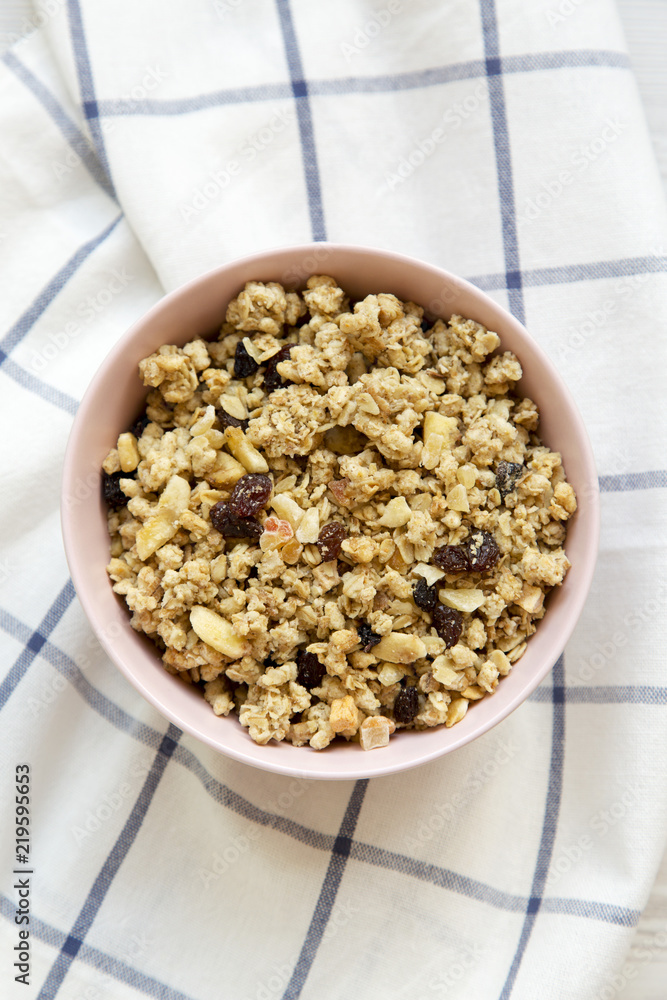 Pink bowl of fruit granola on cloth, overhead view. Close-up. Pink bowl of fruit granola on cloth, overhead view. Close-up.