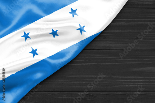 Flag of Honduras and place for text on a dark wooden background photo