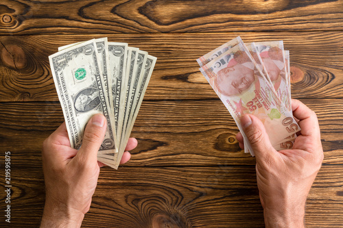 Fotografia Man holding USD and Turkish lira in his hands