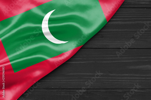Flag of the Maldives and place for text on a dark wooden background