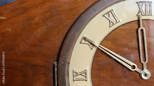 Close up of quarter of old wooden clock face. Minute hand moving fast and stops at 12 o'clock