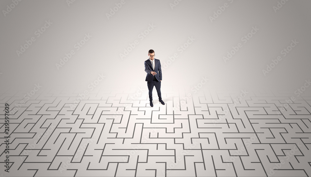 Elegant businessman looking for a solution in a middle of a maze
Elegant businessman looking for a solution in a middle of a maze