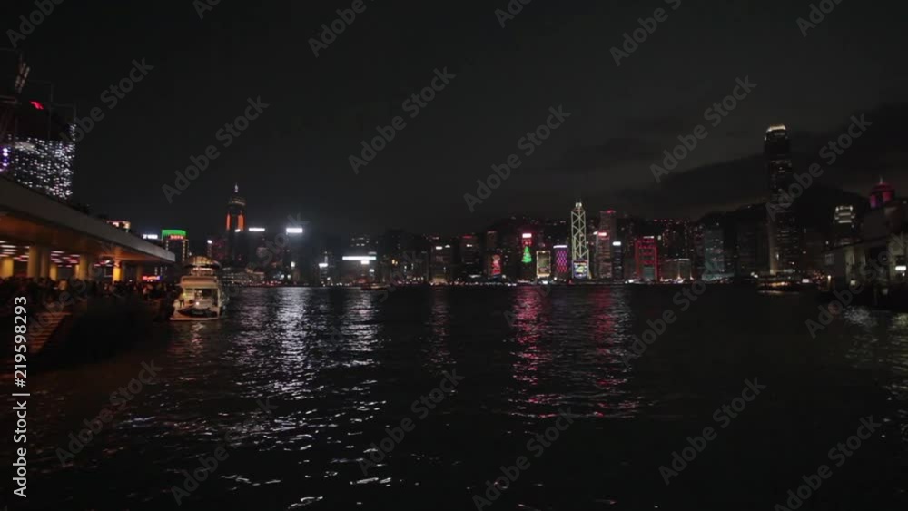 Hong Kong night scene - Central island illuminated by city lights; shot from Star Ferry pier at Kowloon; handheld footage Hong Kong night scene - Central island illuminated by city lights; shot from Star Ferry pier at Kowloon; handheld footage